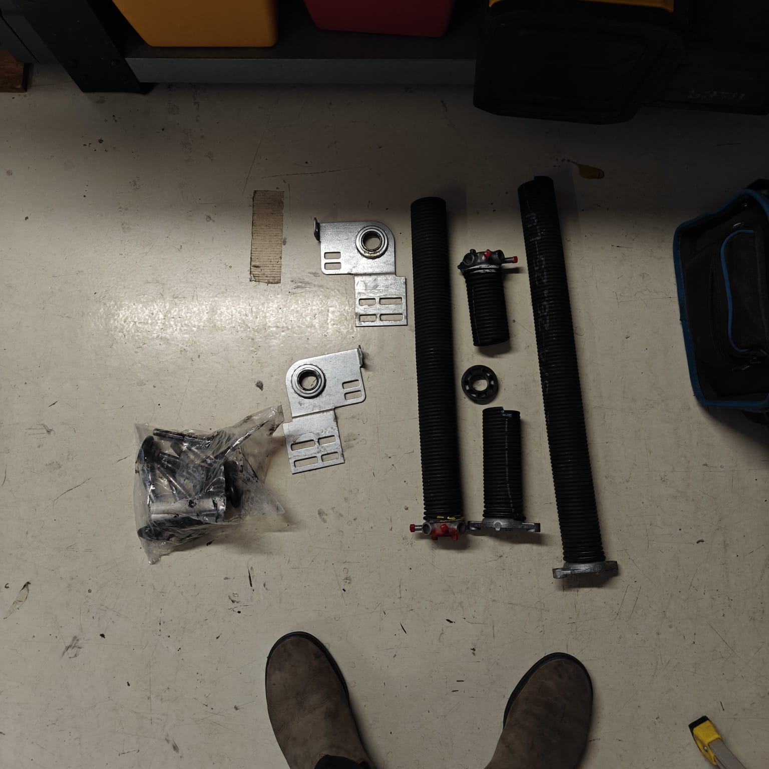 New garage door springs, bearings, and end plates laid out after a Goodyear repair job.